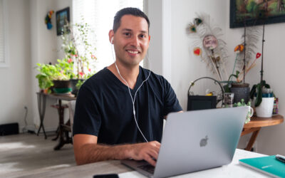 Smiling stroke survivor Johnathan typing on laptop