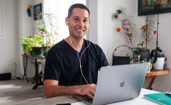 Smiling stroke survivor Johnathan typing on laptop